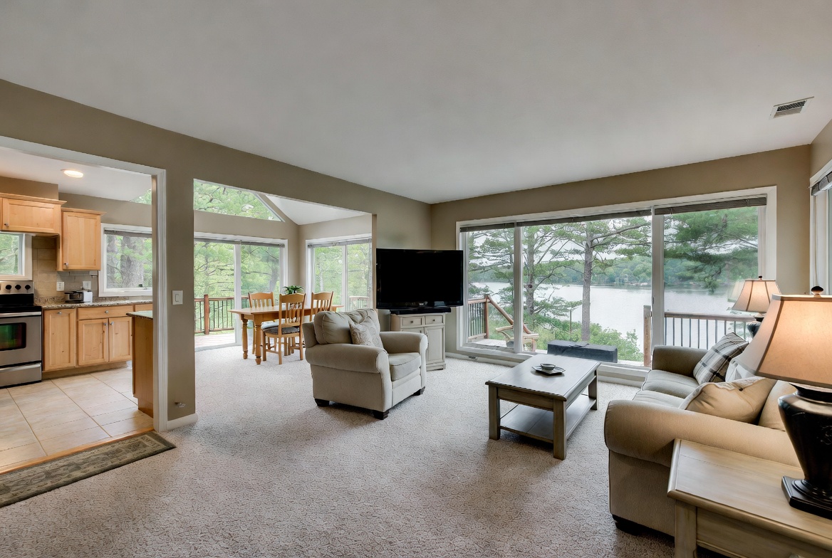 Carpeted lakefront living room with a view of the water